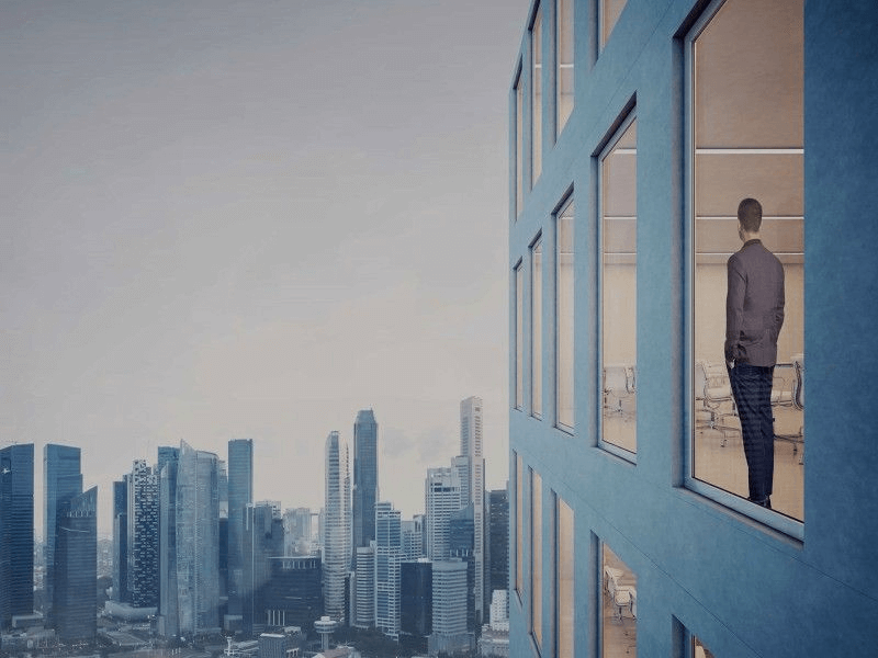 man stood at the window of a very tall building